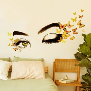 Creative wall sticker featuring eyelashes and butterflies above a cozy bedroom bed