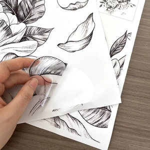 Detail of hand peeling waterproof flower wall sticker showing its transparent texture