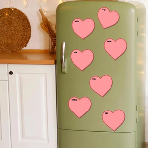Pink heart-shaped weekly magnetic planners on a green vintage refrigerator