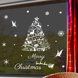 Detail of white Christmas reindeer and snowflake static window decals on a glass surface