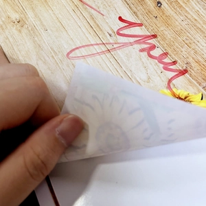Close-up of hand peeling a sunflower and red cursive text DIY wall sticker
