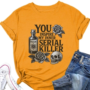 Detailed close-up of orange t-shirt featuring gothic skull and rose graphic print