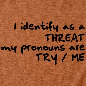 Gros plan sur la texture du coton avec l'imprimé 'I identify as a threat'