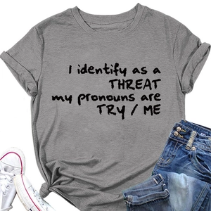 T-shirt gris posé à plat avec slogan 'I identify as a THREAT' assorti à un jean en denim bleu
