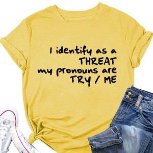 Détail d'un t-shirt jaune avec lettrage noir, assorti à un jean en denim et baskets