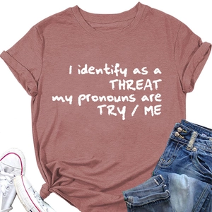 Détail d'un t-shirt rouge à slogan avec manches retroussées et ourlet noué