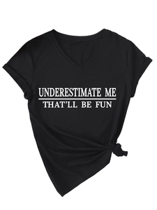 Détail du t-shirt col en V avec texte UNDERESTIMATE ME et nœud élégant à l'ourlet