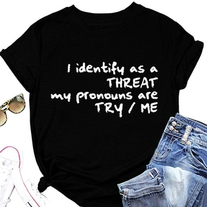 Détail de l'imprimé I Identify As A Threat sur t-shirt noir avec accessoires de mode décontractés