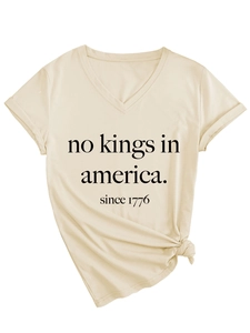 Détail du t-shirt beige à col en V avec imprimé No Kings in America et nœud sur le devant