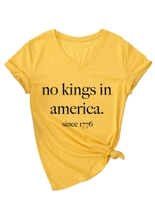 Détail du t-shirt jaune col en V avec imprimé No Kings in America et nœud décoratif