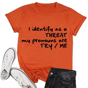 Gros plan d'un t-shirt orange à col rond avec slogan TRY/ME et texture en coton doux