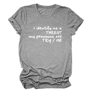 Détail d'un t-shirt gris gaufré avec le slogan imprimé I Identify As A Threat en blanc