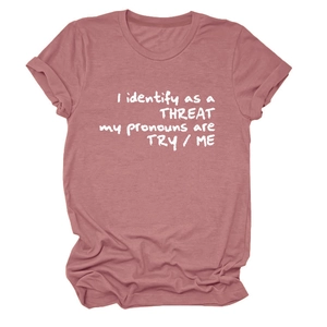 Détail des manches retroussées et imprimé graphique blanc sur un t-shirt rose poudré