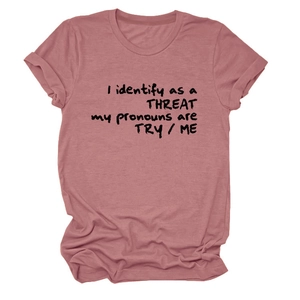 Détail du t-shirt rose poudré avec impression du slogan I identify as a threat