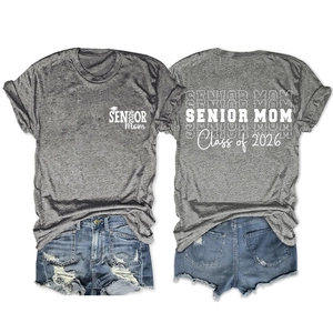 Détail de l'imprimé senior mom class of 2026 sur un t-shirt gris et un short en jean
