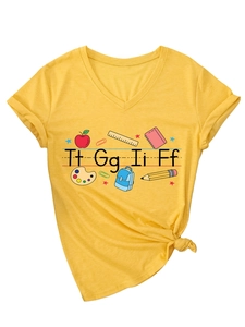Dettaglio maglietta gialla con scollo a V, motivi scolastici e stampa Tt Gg Ii Ff