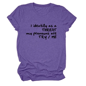 Détail d'un t-shirt violet chiné avec impression du slogan 'I identify as a threat'