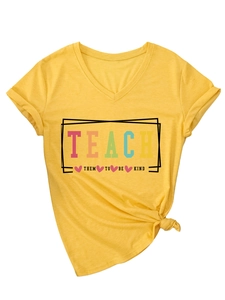 Detail of yellow V-neck T-shirt showing Teach Them To Be Kind print and knot hem