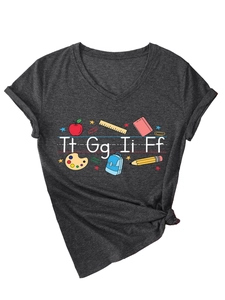 Dettaglio della t-shirt grigio scuro con scollo a V e icone scolastiche come mele e righelli
