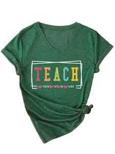 Close-up of deep green V-neck T-shirt featuring a colorful 'TEACH THEM TO BE KIND' print