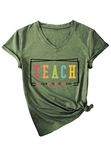 Close-up of V-neck T-shirt detail showing Teach Them To Be Kind print and rolled sleeves