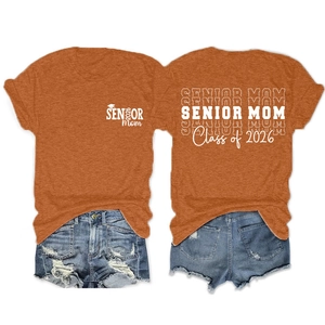 Détail de l'imprimé Senior Mom 2026 sur un t-shirt orange et un short en jean usé