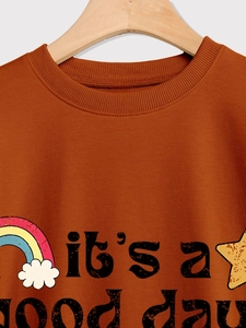 Détail du col côtelé et de l'imprimé coloré 'it's a good day' sur le sweatshirt caramel