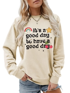 Détail d'un sweat crème avec citation 'it's a good day' et motifs floraux colorés