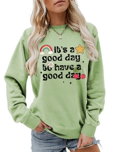 Détails du col rond et des motifs de dessins animés sur le sweat-shirt vert clair