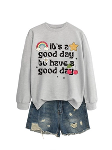 Détail du sweat-shirt gris avec illustrations colorées et short en jean vieilli