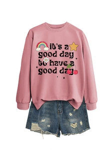 Gros plan d'un sweat-shirt rose à manches longues avec imprimé rétro et short en jean