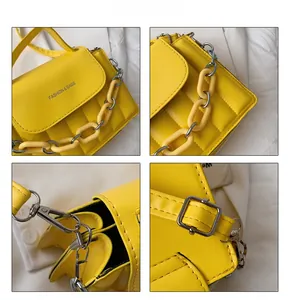 Detail view of yellow quilted crossbody bag with chain strap and silver hardware accents
