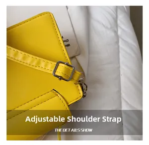 Detail of adjustable yellow leather shoulder strap with silver buckle on a square bag