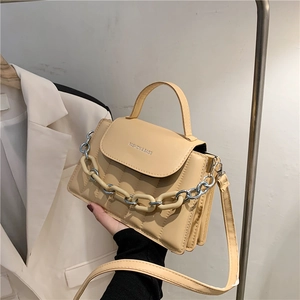 Detail of apricot quilted handbag featuring gold metal chain and Fashion & Bags lettering