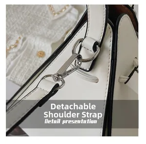 Détail du sac en cuir blanc avec bandoulière amovible et fermoir mousqueton argenté