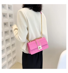 Close-up of pink crocodile texture small square bag with gold chain and metal lock