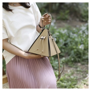 Vue détaillée d'un sac pyramide beige avec fermeture à cordon et nœud élégant