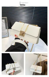 Detail view of white crocodile pattern square bag with gold chain and metal lock