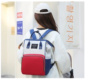 Vue arrière d'un sac à dos à langer élégant avec design tricolore et bandoulières