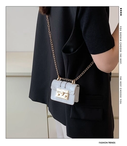 Detailed view of mini white stone pattern bag with golden chain on model shoulder