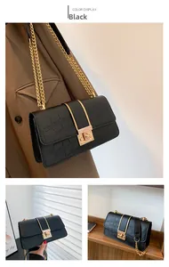 Close-up of black crocodile pattern shoulder bag with gold metal chain and buckle
