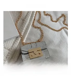 Détail du mini sac argenté à motif crocodile avec fermoir en métal doré et chaîne
