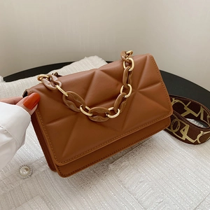 Detail of brown quilted square bag with gold chain handle and patterned woven strap