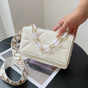Detail of off-white quilted shoulder bag with 3D triangle pattern and patterned strap