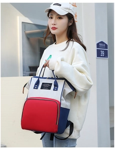 Photo de rue d'un grand sac à dos à langer tricolore rouge blanc et bleu marine