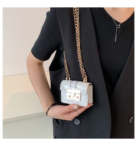 Détail du mini sac bandoulière blanc embossé crocodile avec fermoir et chaîne dorés