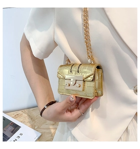 Close-up of gold crocodile-patterned chain bag with elegant metallic lock buckle