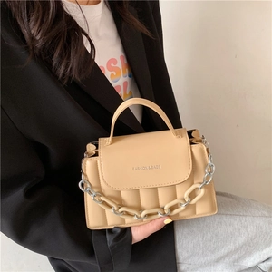 Detail of beige quilted PU leather crossbody bag with chunky resin and metal chain strap