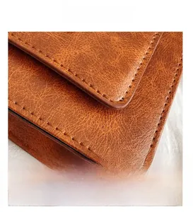 Détail macro de la texture du cuir marron et des coutures de précision du sac rétro