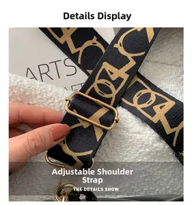 Close-up of adjustable woven shoulder strap with gold hardware and geometric logo pattern